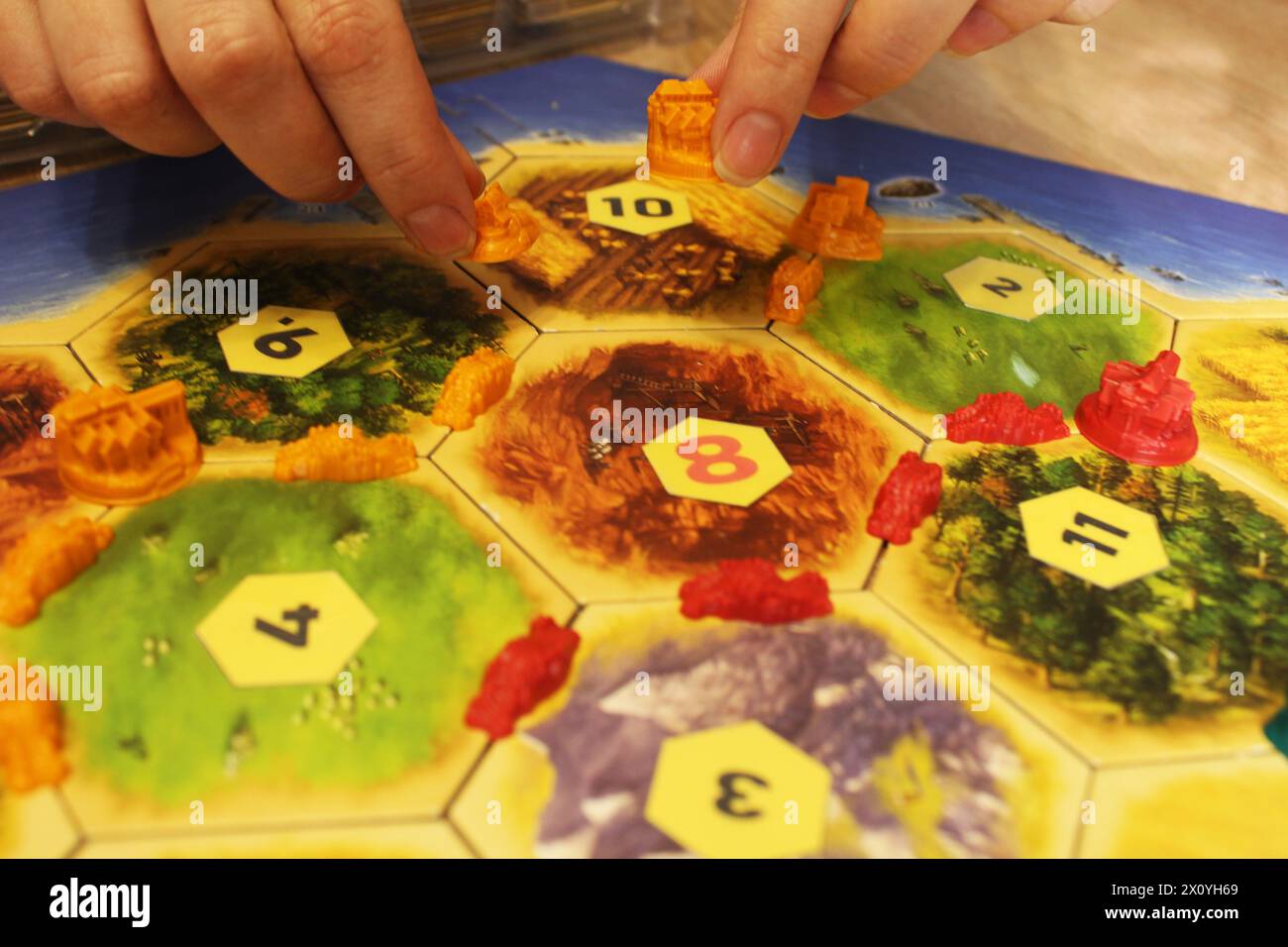 Mozyr, Weißrussland, 1. April 2024: Ein catan-Brettspiel, das eine Siedlung durch eine Stadt ersetzt. Upgrade Für Abrechnung, Entwicklung Von Spielertoken. Stockfoto