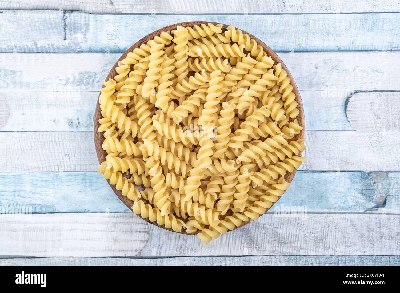 Rohe italienische Fusilli Spiralnudeln auf einem Holzteller. Nahaufnahme der Lebensmittelfotografie. Stockfoto