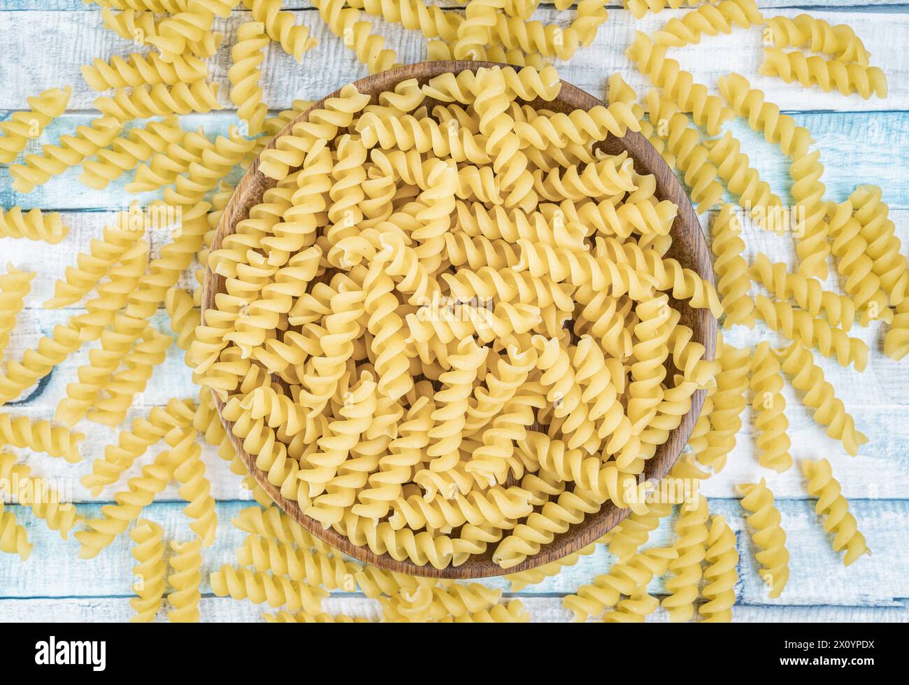 Rohe italienische Fusilli Spiralnudeln auf einem Holzteller. Nahaufnahme der Lebensmittelfotografie. Stockfoto