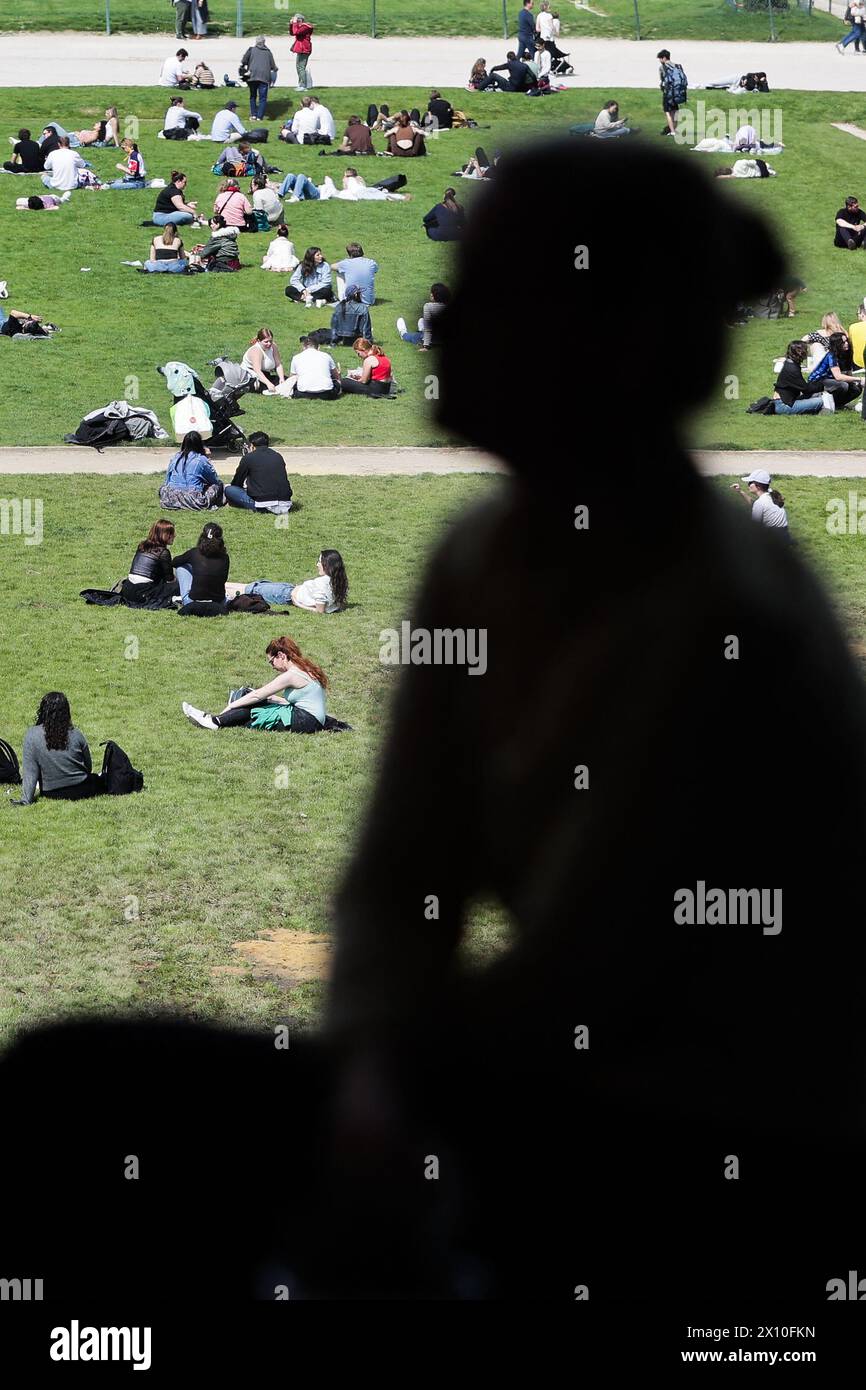 Paris, Frankreich. April 2024. Dieses am 14. April 2024 aufgenommene Foto zeigt Menschen, die die Sonne auf den Champs de Mars am Fuße des Eiffelturms in Paris genießen.Foto: Thibaud MORITZ/ABACAPRESS.COM Credit: Abaca Press/Alamy Live News Stockfoto