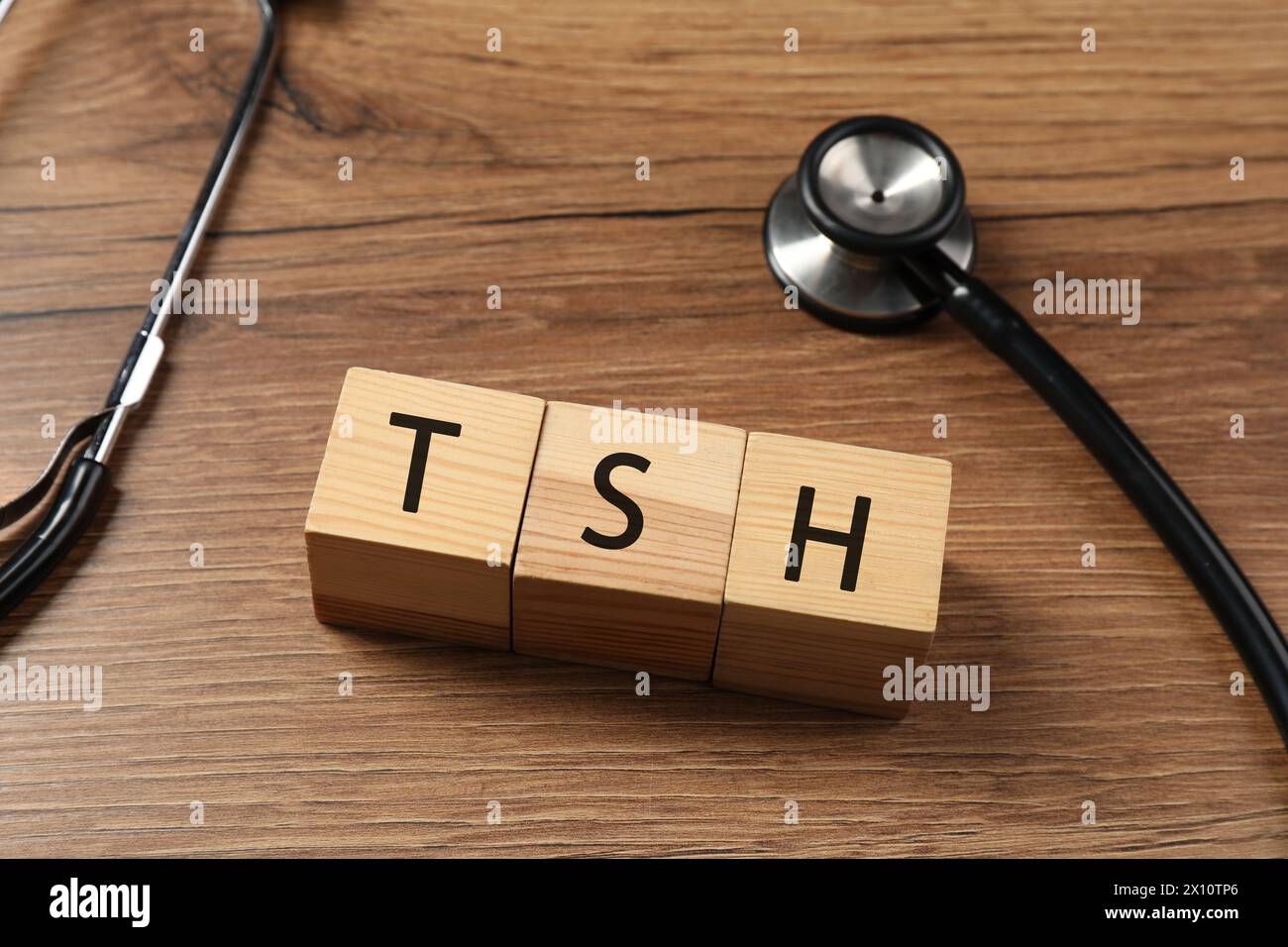 Endokrinologie. Stethoskop und Würfel mit Schilddrüsenhormonen auf Holztisch Stockfoto