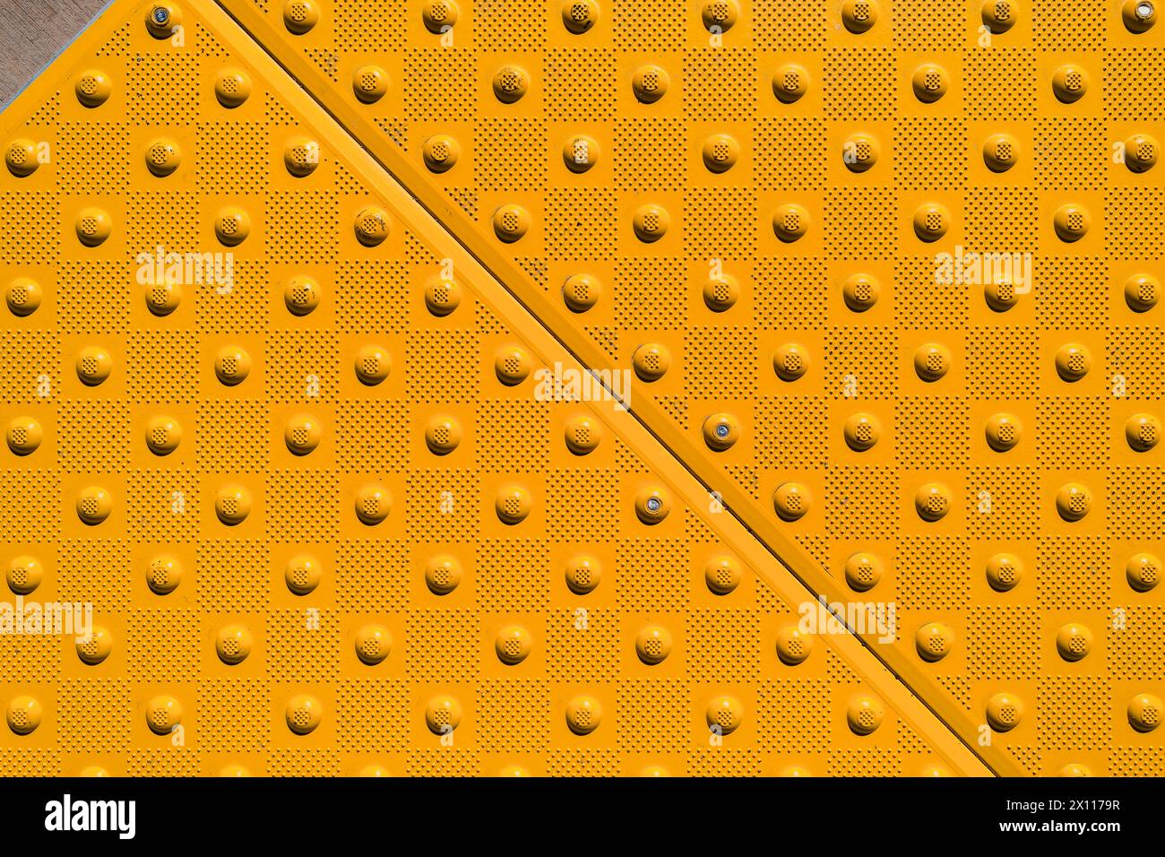 Nahaufnahme einer gelben ADA-Warntafel auf einem Gehsteig aus Beton Stockfoto