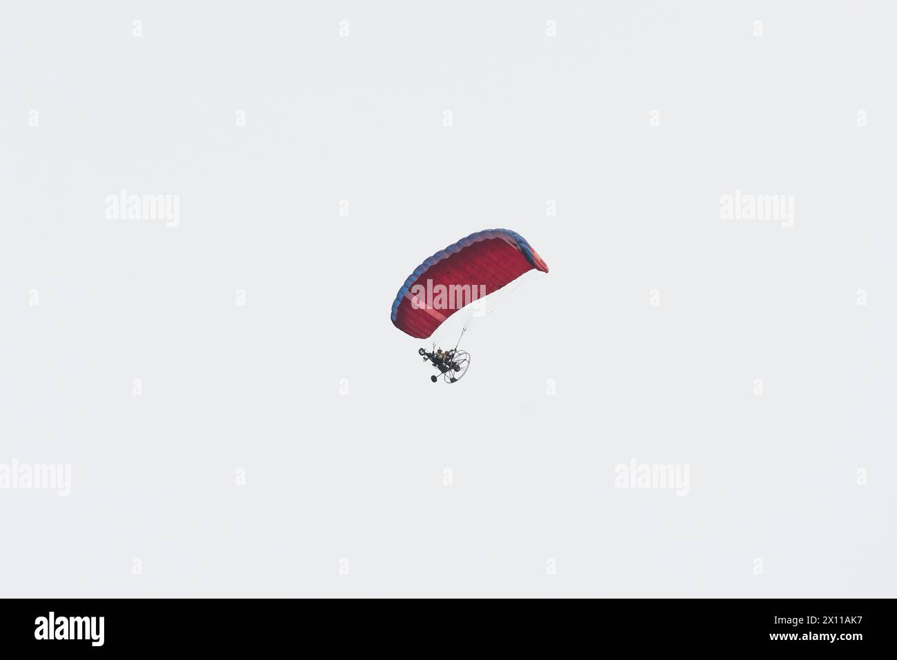 Ein angetriebener Gleitschirmflieger fliegt durch den Himmel Stockfoto