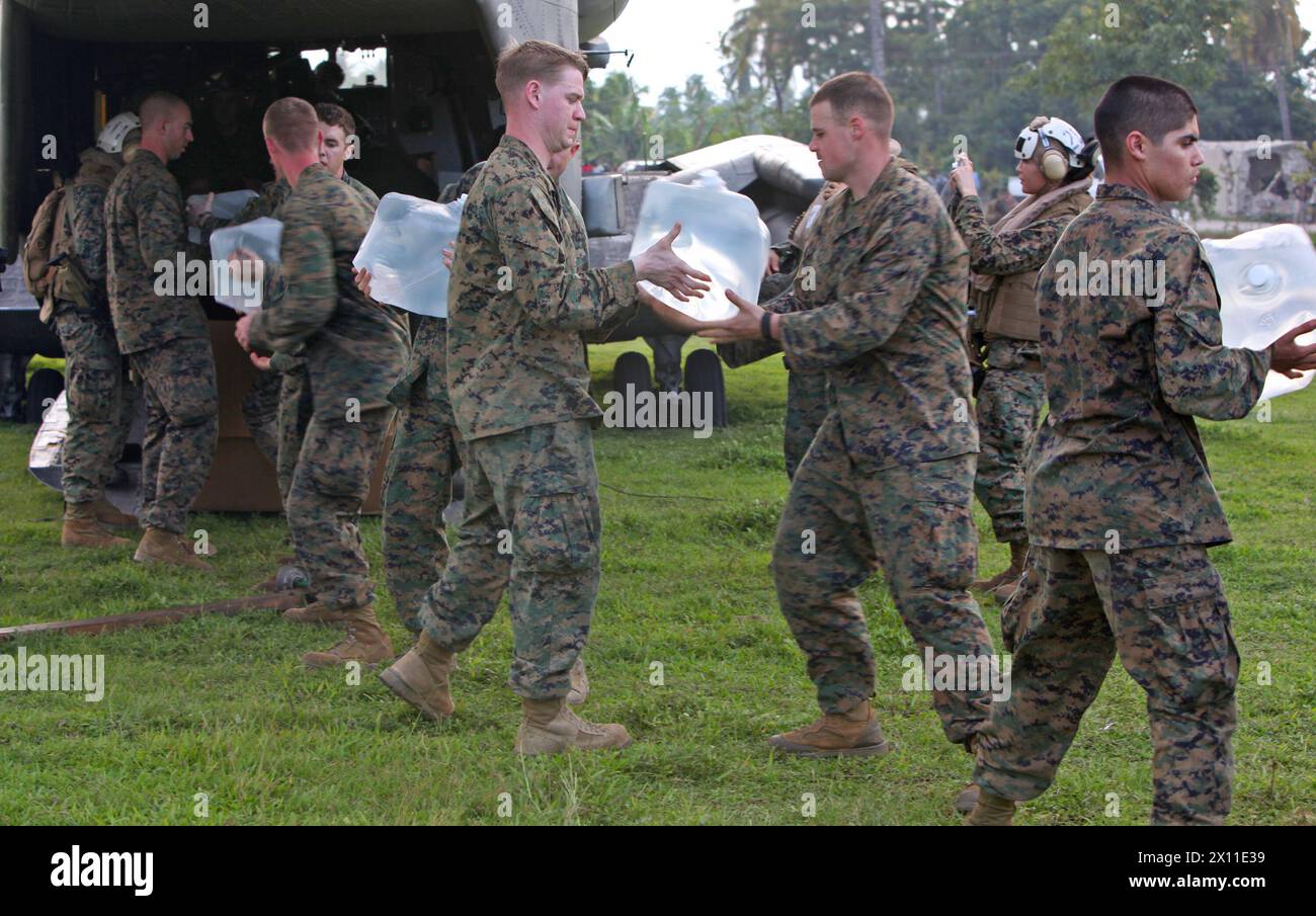 Marines mit Battalion Landing Team, 3. Bataillon, 2. Marine Regiment, 22. Marine Expeditionary Unit, entladen Wasser von der Rückseite eines CH-53E Super Hengstes für Erdbebenopfer in Leogane, Haiti, 20. Januar 2010. Stockfoto