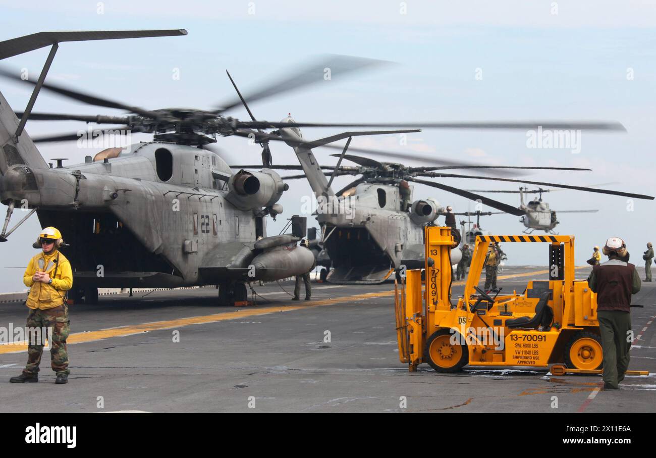 CH-53E Super Hengste und UH-1N Hueys von der Marine Heavy Helicopter Squadron 461 (verstärkt), 22. Marine Expeditionary Unit, bereiten sich auf den Start vor, um den ersten Satz Personal für ihre Mission nach Haiti am 19. Januar 2010 zu heben. Stockfoto