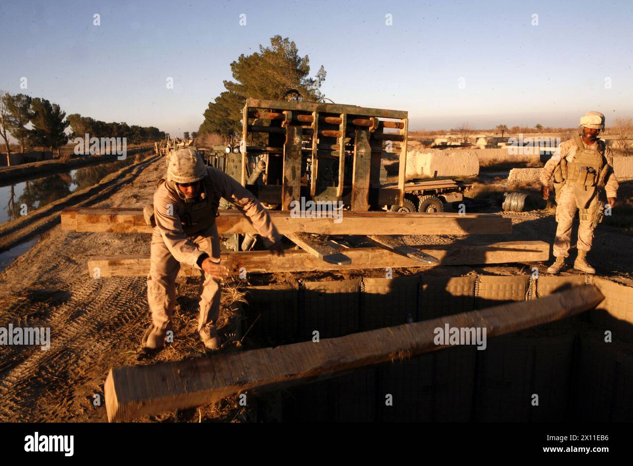 Afghanistan: CPL. James A. Pabey, ein Kraftverkehrsunternehmen der Alpha Company, 2. CEB, entlädt Bauholz, das benötigt wird, um ein Dach auf einem Beobachtungsposten auf der Route Cowboys, Provinz Helmand, Afghanistan, 7. Januar 2010 zu bauen. Während des Einsatzes auf der Route Cowboys baute die 2. CEB drei Beobachtungsposten. Stockfoto