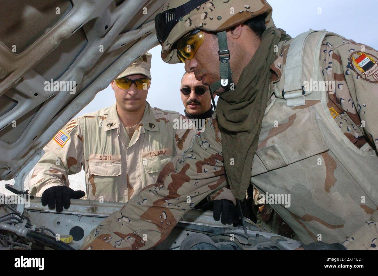 Staff-Sgt. Mark Scott, 3/7 Cav., beauftragt einen irakischen Armeesoldaten bei einer Vorkampfkontrolle seines Fahrzeugs im Camp Volunteer, Irak CA. Januar (2003, Datum pro Metadaten) Stockfoto