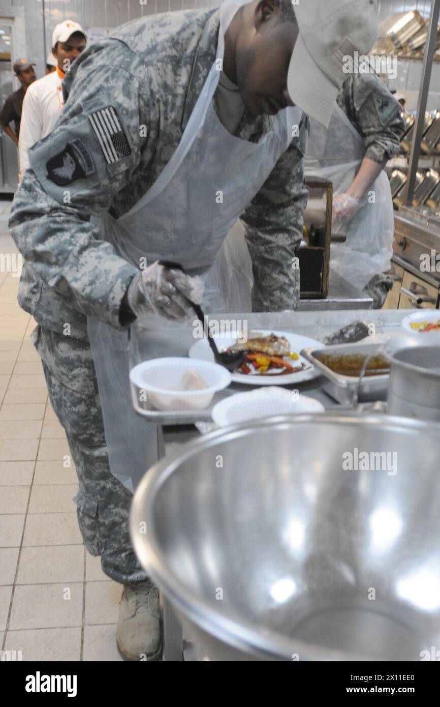 Sgt. Jamaal Smith, ein Spezialist für Lebensmitteldienstleistungen, der Kompanie B, Division Special Trupps Battalion, 1. Panzerdivision, fügt eine braune Soße zu einem Hauptgericht hinzu. Smith, ein gebürtiger Summerton, S.C., war Teamleiter bei einem „Iron Chef“-Wettbewerb am 27. März im DeFleury Dining Facility CA. März 2004 Stockfoto