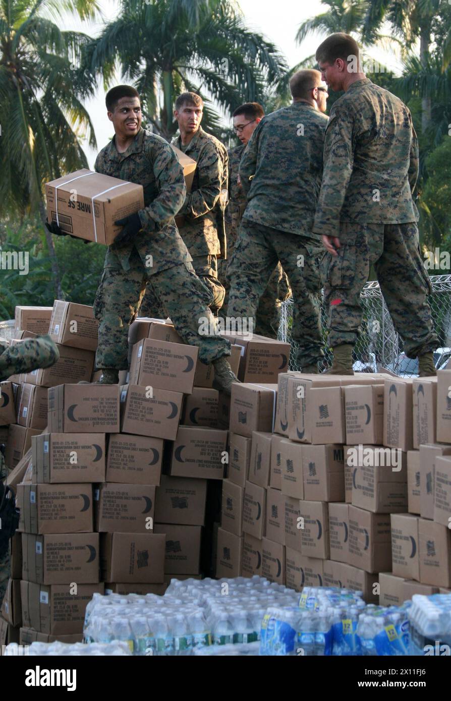 Marines vom Kampflogistik-Bataillon 22, 22. Marine Expeditionary Unit, beladen einen 7-Tonnen-Lkw mit Hilfsgütern für die Verteilung in Petit Goave, Haiti, 24. Januar 2010. Als Reaktion auf ein verheerendes Erdbeben, das das Land Haiti heimsuchte, begannen Marines und Seeleute der 22. MEU, Hilfsgüter zu liefern und medizinische Hilfe zur Unterstützung der Operation Unified Response am 19. Januar zu leisten. Stockfoto