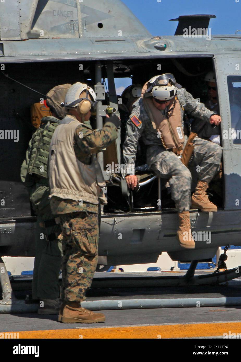 Marines der 22. Marine Expeditionary Unit, grüßen Lt. General Ken Ken Keen, Befehlshaber der Joint Task Force Haiti, als er die UH-1N Huey von der Marine Heavy Helicopter Squadron 461 (verstärkt) an Bord der USS Bataan verlässt, 25. Januar 2010. Die 22. MEU hat seit dem 19. Januar humanitäre Hilfe und Katastrophenhilfemissionen in ganz Haiti durchgeführt. Stockfoto