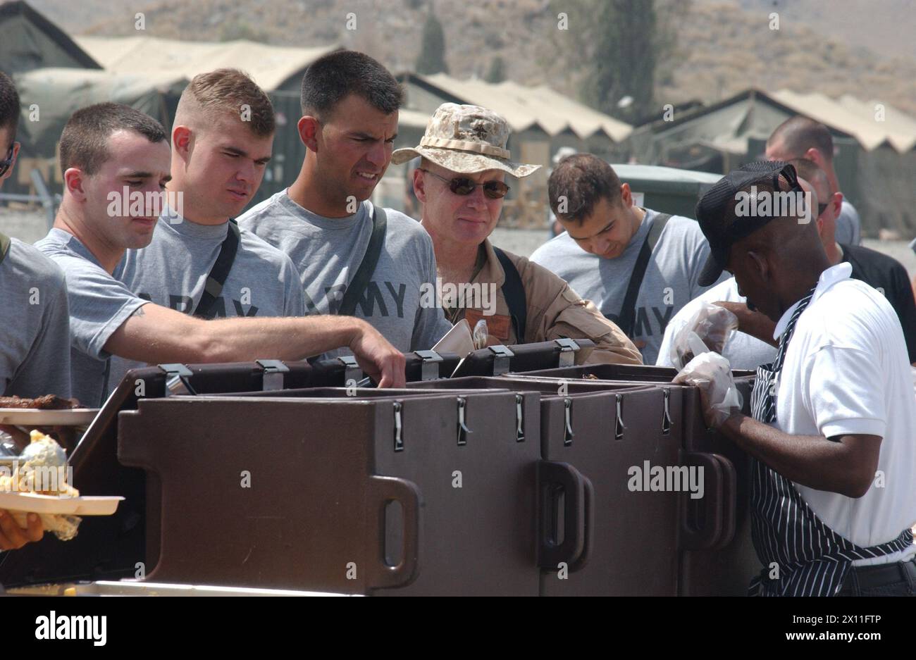 Am 4. Juli 2004 feierten Soldaten, die dem 1/501. Fallschirmjäger-Infanterieregiment (PIR) und anderen Koalitionsstreitkräften zugewiesen wurden, den Unabhängigkeitstag mit Sportwettbewerben und Unterhaltung und Essen (hier zu sehen) in Salerno, Afghanistan. Stockfoto