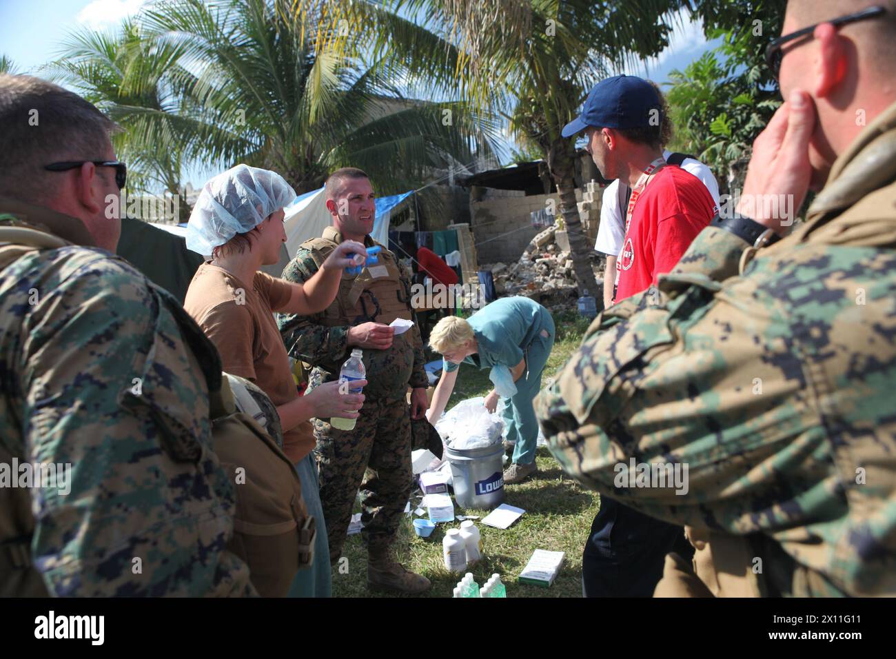 Marinestützpunkt Matt Swartz (Mitte), Chirurg für Bataillon Landing Team, 3. Bataillon, 2. Marine Regiment, 22. Marine Expeditionary Unit, und BLT-Korps sprechen mit kanadischem medizinischem Personal in einer Klinik am Stadtrand von Leogane, Haiti, 22. Januar 2010. Stockfoto