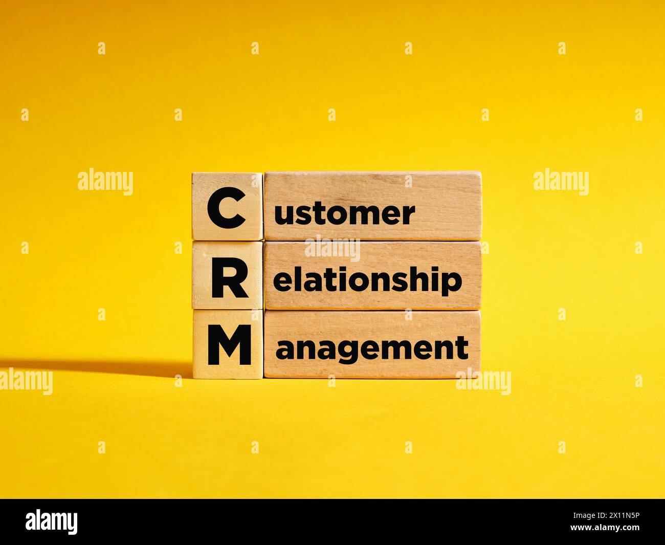 Holzwürfel mit dem Akronym CRM Customer Relationship Management. Automatisierungsstrategien für die Interaktion mit Kunden. Steigern Sie den Umsatz, optimieren Sie m Stockfoto