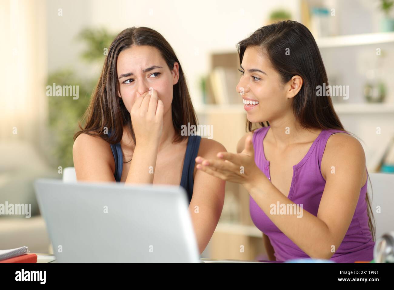 Frau mit schlechtem Atem, die zu Hause mit einem angeekelten Freund redet Stockfoto