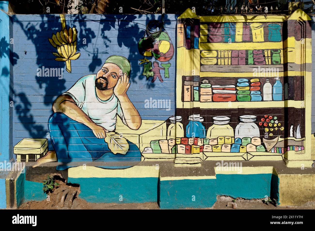 Ein farbenfrohes Wandgemälde in der Gegend von Byculla in Mumbai, Indien, das einen Verkäufer von Verbrauchsmaterialien an seinem Straßenstand darstellt Stockfoto