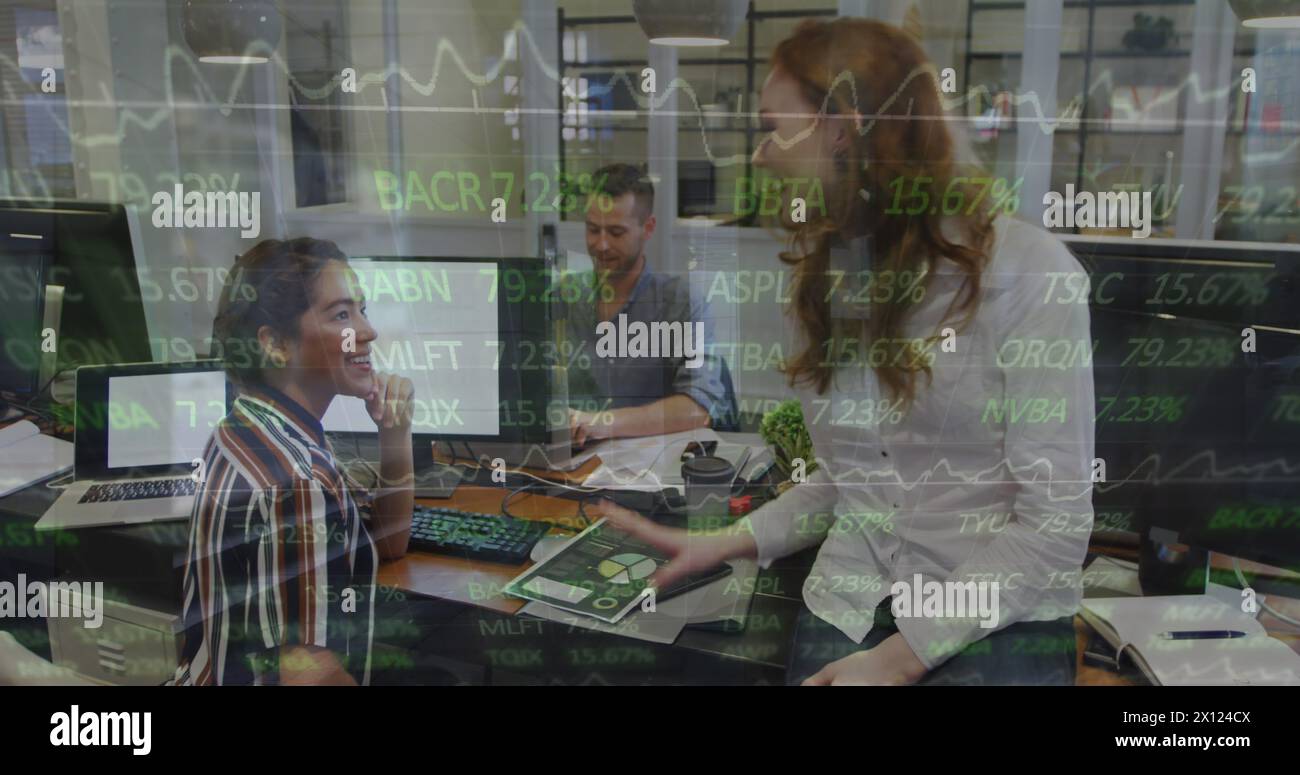 Drei Geschäftsfrauen, eine kaukasierin und zwei Birassisten, arbeiten in einem modernen Büro zusammen Stockfoto