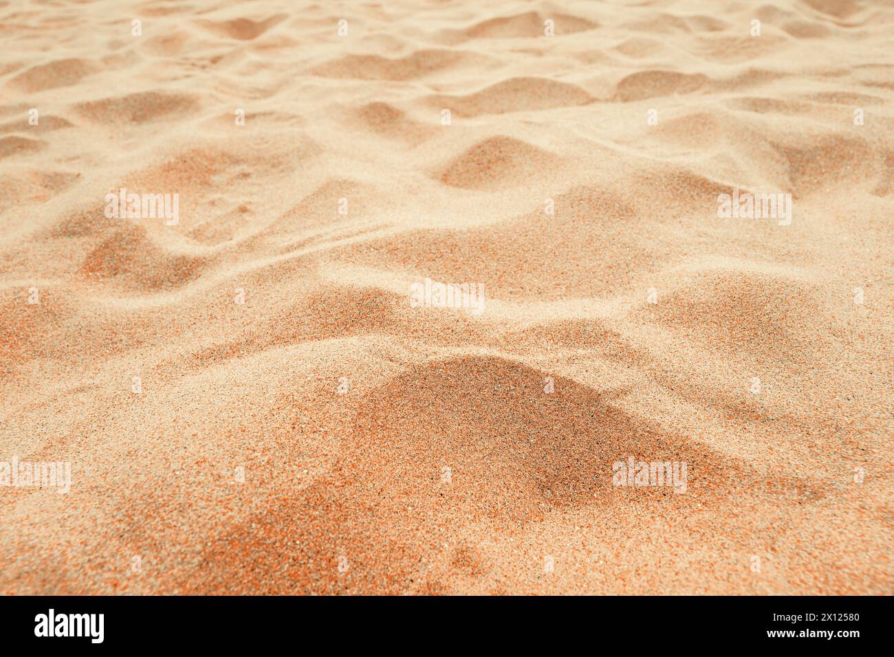 Strand Sandhintergrund, Nahaufnahme, flacher Blick auf die braune Sandoberfläche im tropischen Resort. Urlaubs- und Sommerferienkonzept. Selektiver Fokus. Stockfoto