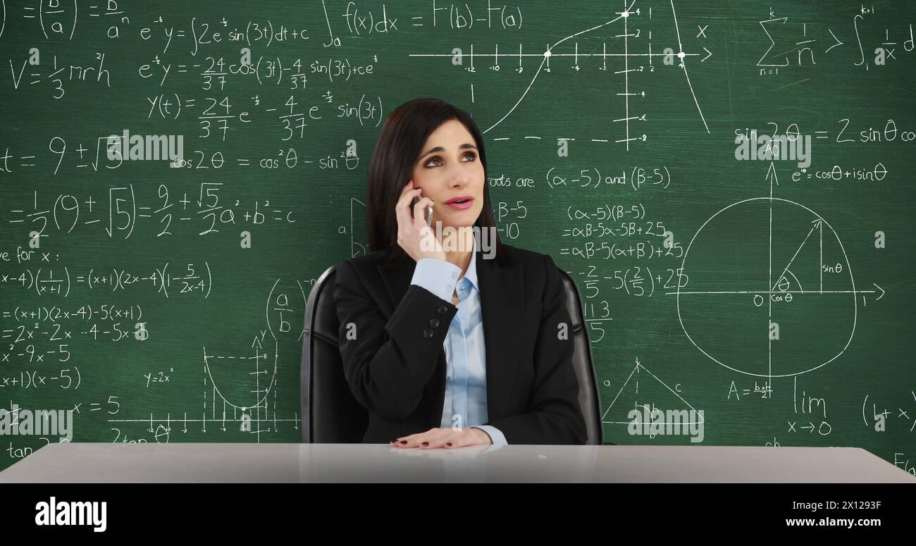 Bild einer jungen, lächelnden kaukasischen Frau, die in der Hüfte oben an einem Schreibtisch sitzt und mit dem Smartphone spricht Stockfoto