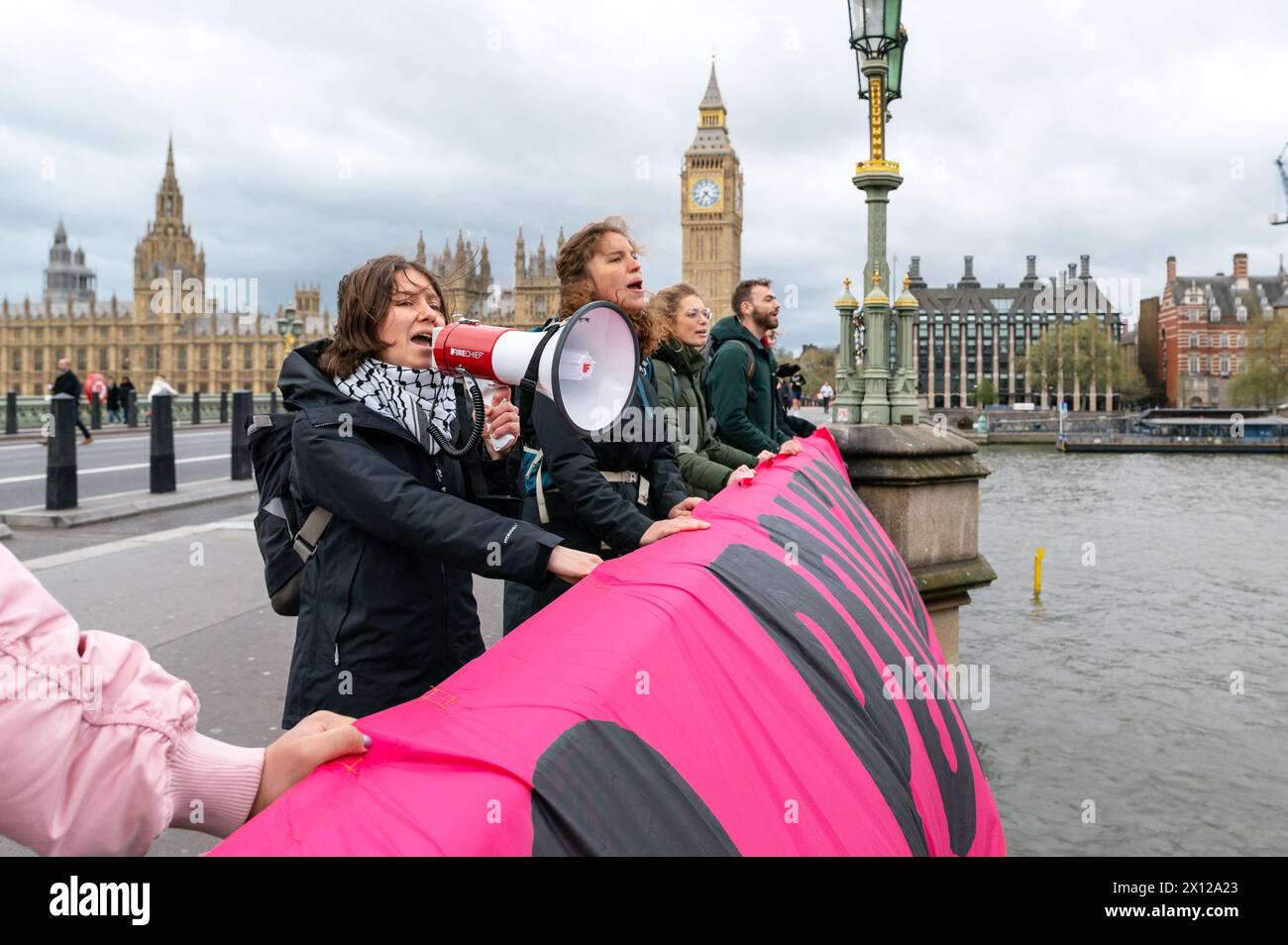 London, Großbritannien. 15. April 2024. Klimaaktivisten von Climate Resistance werfen ein Banner von der Westminster Bridge mit der Aufschrift „Stop Poluting Politics“. Anrede: Andrea Domeniconi/Alamy Live News Stockfoto