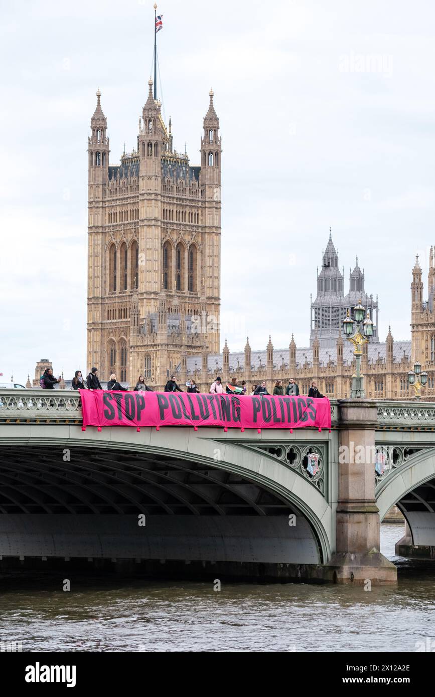 London, Großbritannien. 15. April 2024. Klimaaktivisten von Climate Resistance werfen ein Banner von der Westminster Bridge mit der Aufschrift „Stop Poluting Politics“. Anrede: Andrea Domeniconi/Alamy Live News Stockfoto