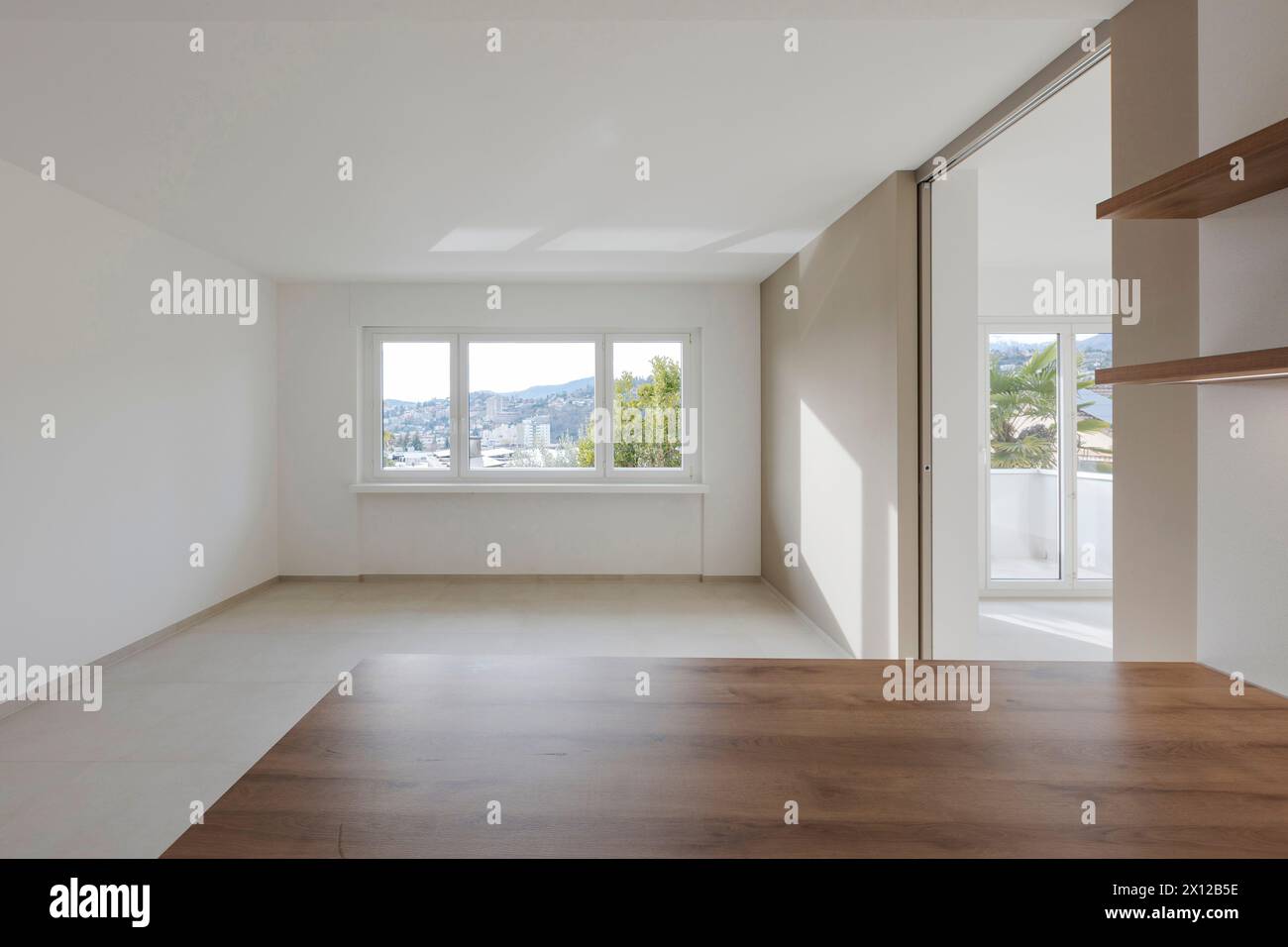 Blick auf ein leeres Esszimmer mit einem großen Fenster im Hintergrund. Moderne, stilisierte Innenarchitektur. Stockfoto