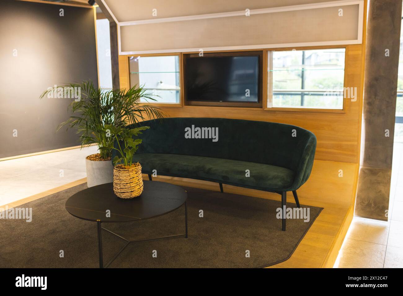 Keine Leute anwesend, nur stilvolles Zimmer mit einem grünen Sofa und einem runden Couchtisch Stockfoto