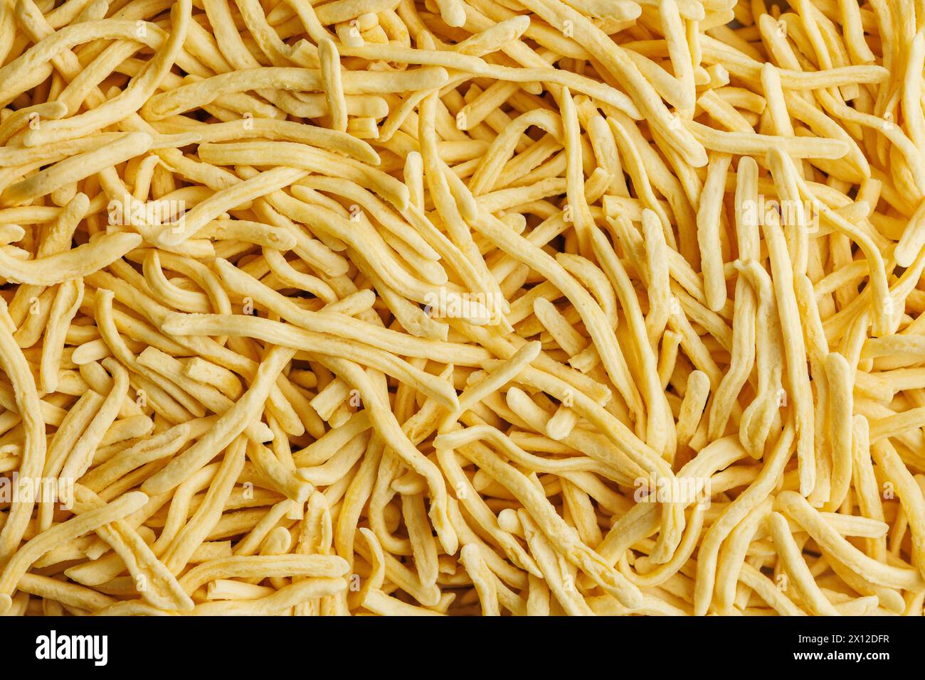 Viele ungekochte Spätzle-Pasta. Draufsicht. Stockfoto