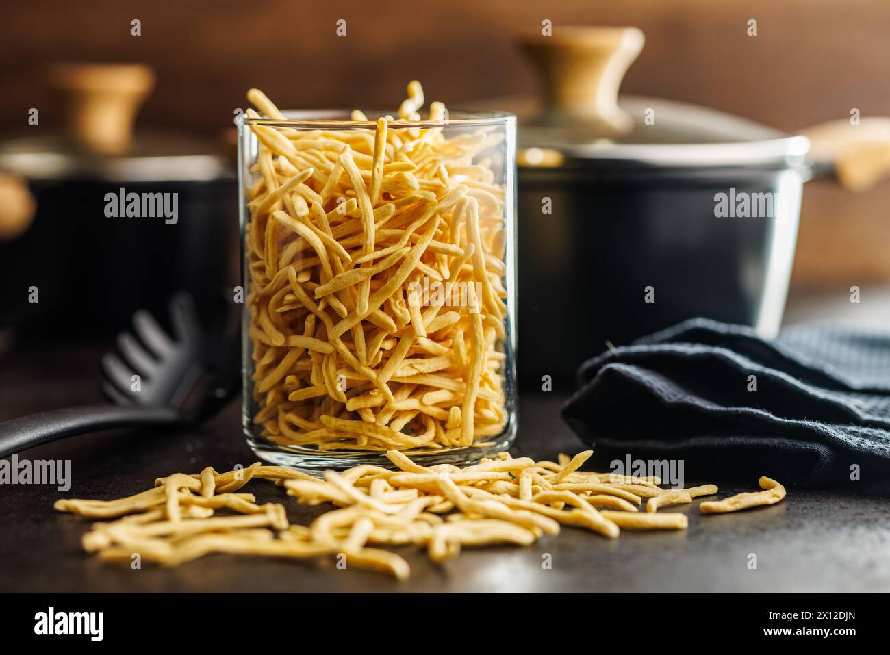 Ungekochte Spätzle Nudeln im Glas auf einem Küchentisch. Stockfoto
