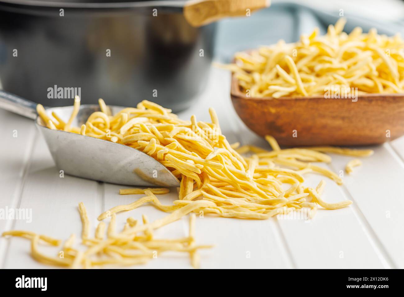 Ungekochte Spätzle Nudeln in Löffel auf einem Küchentisch. Stockfoto