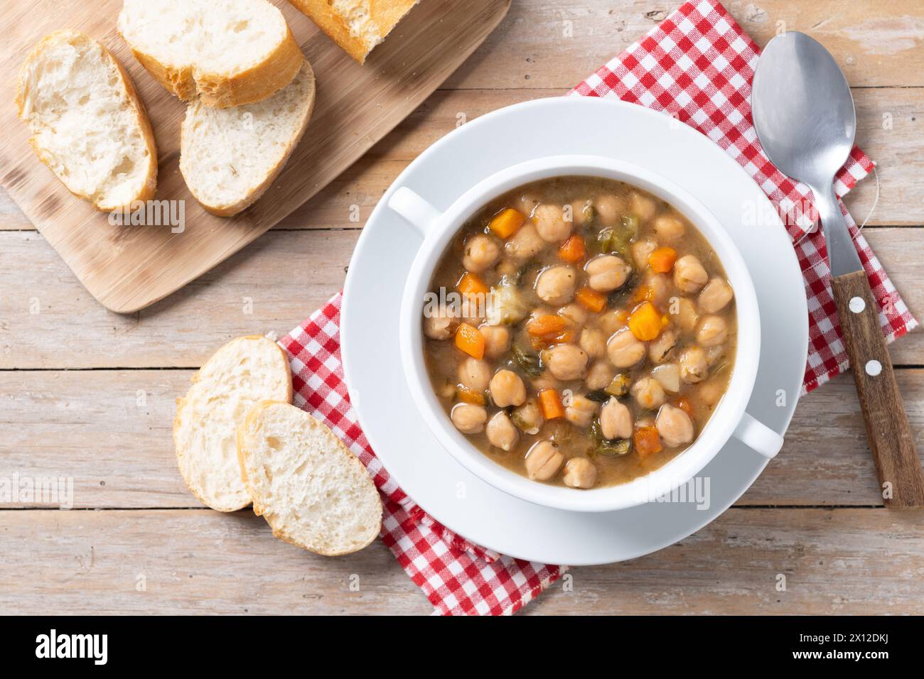 Kichererbsensuppe mit Gemüse in einer Schüssel auf Holztisch Stockfoto
