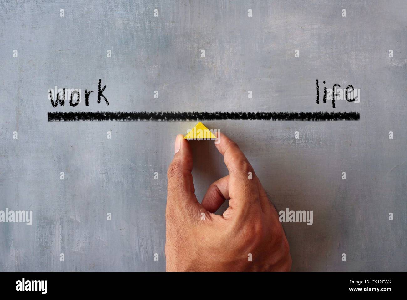 Draufsicht eines handhaltenden Holzdreiecks. Work-Life-Balance-Konzept. Stockfoto