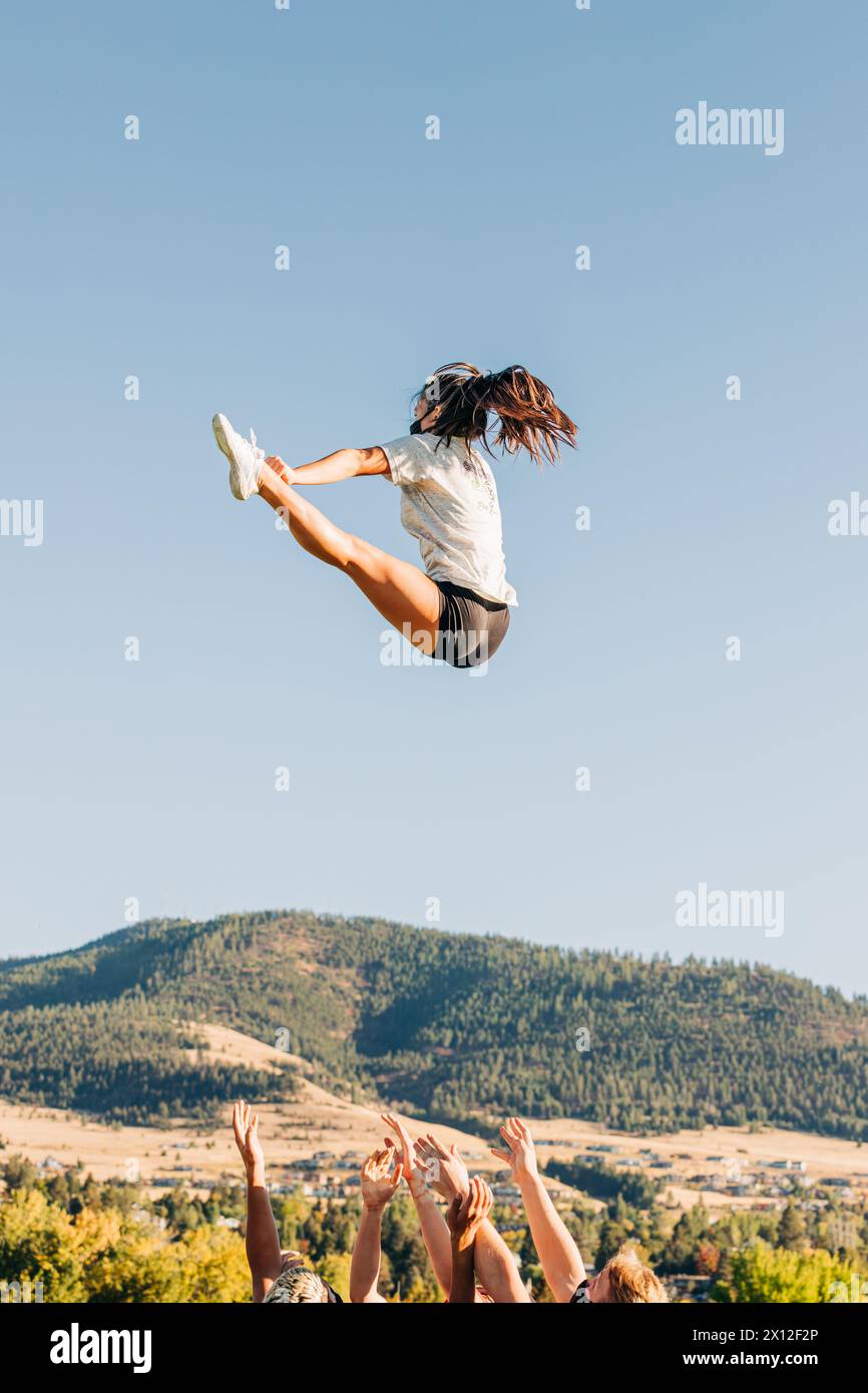 Cheerleaderin fliegt während der Cheerleaderpraxis durch die Luft Stockfoto