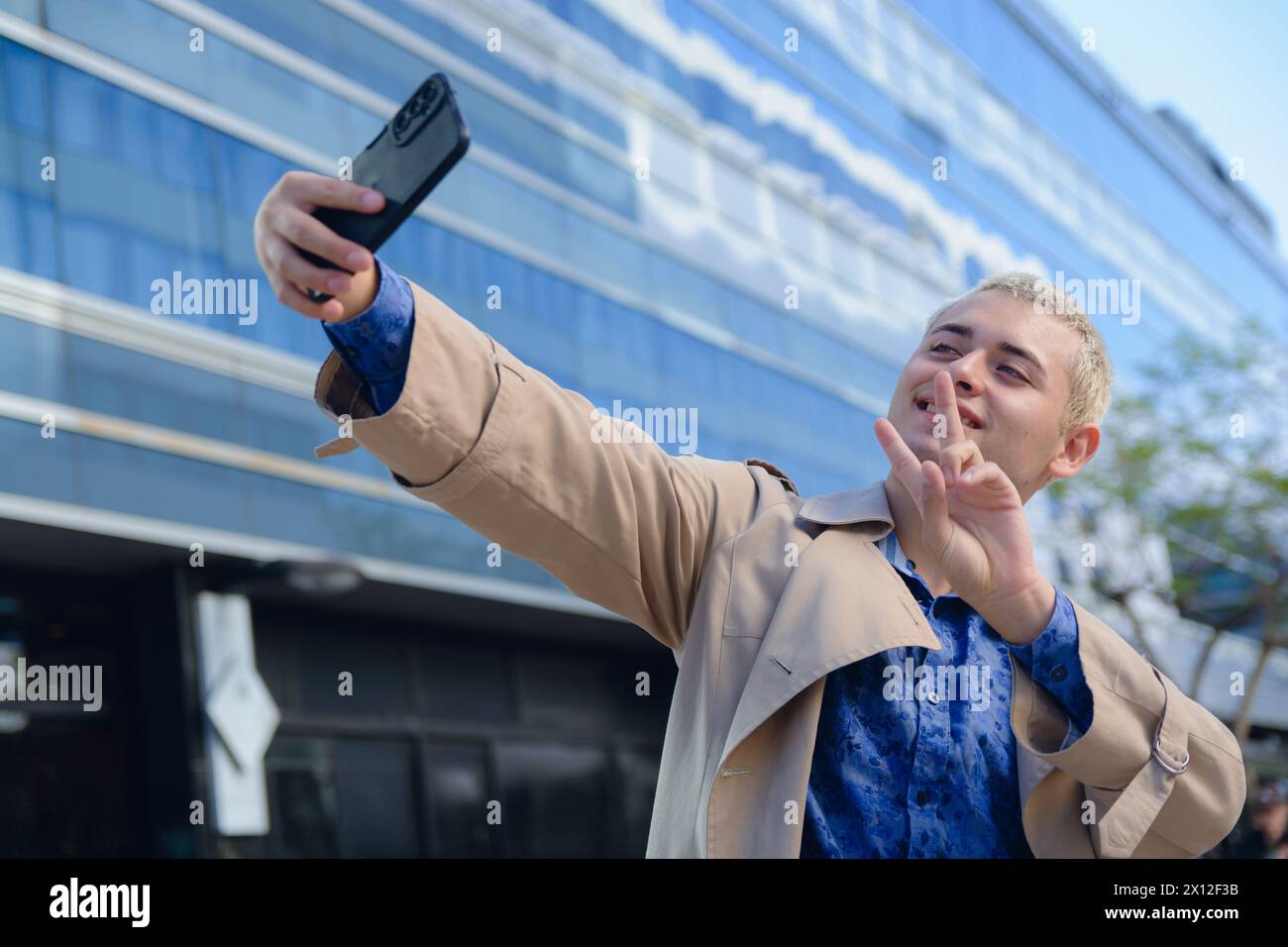 Junger lateinamerikanischer argentinischer Mann, hübscher blonder Unternehmer in formeller Kleidung, der im Freien Selfie-Foto mit seinem Handy macht Stockfoto