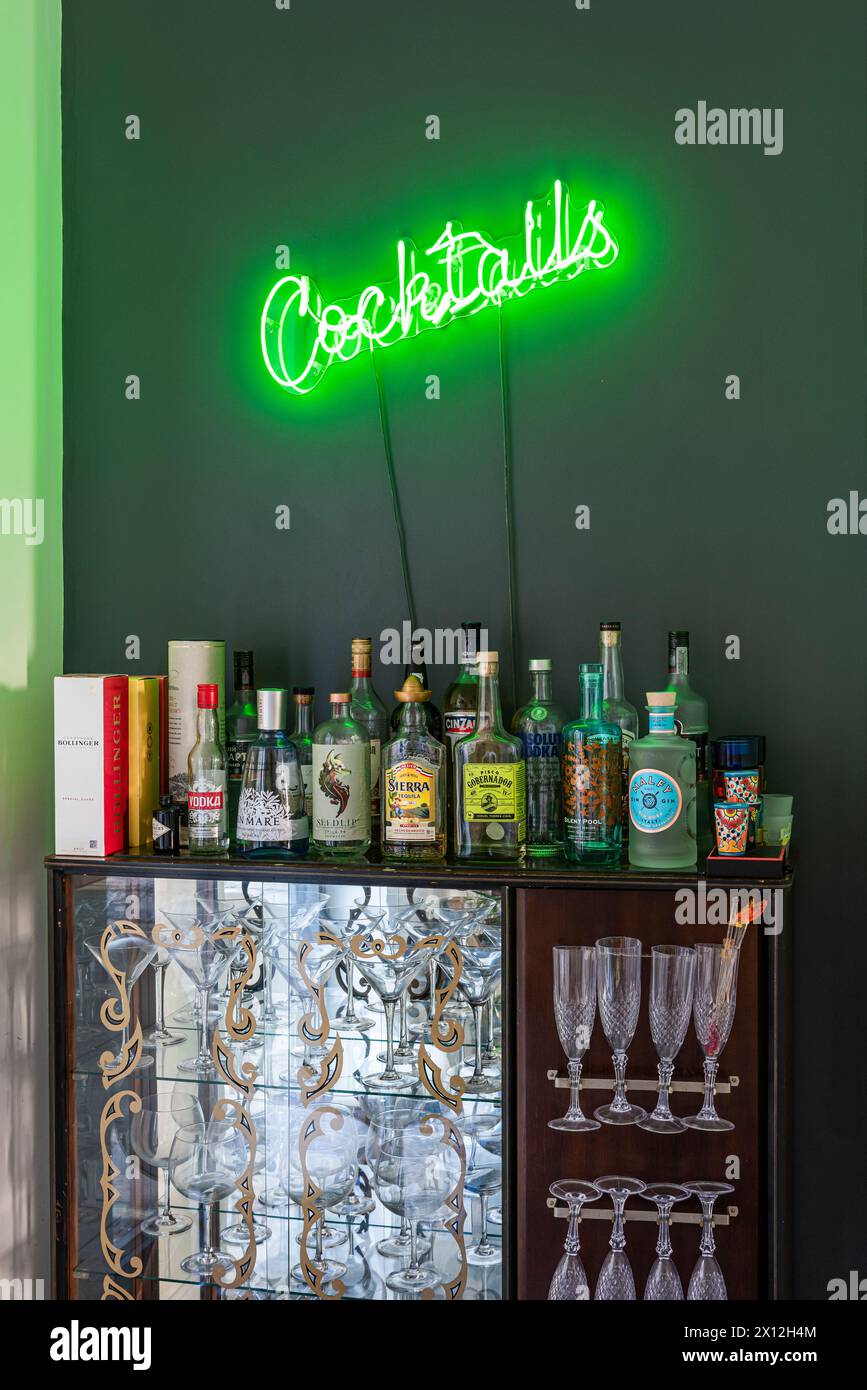 Cocktailbar mit grünem Neonlicht in London Flat, Großbritannien Stockfoto
