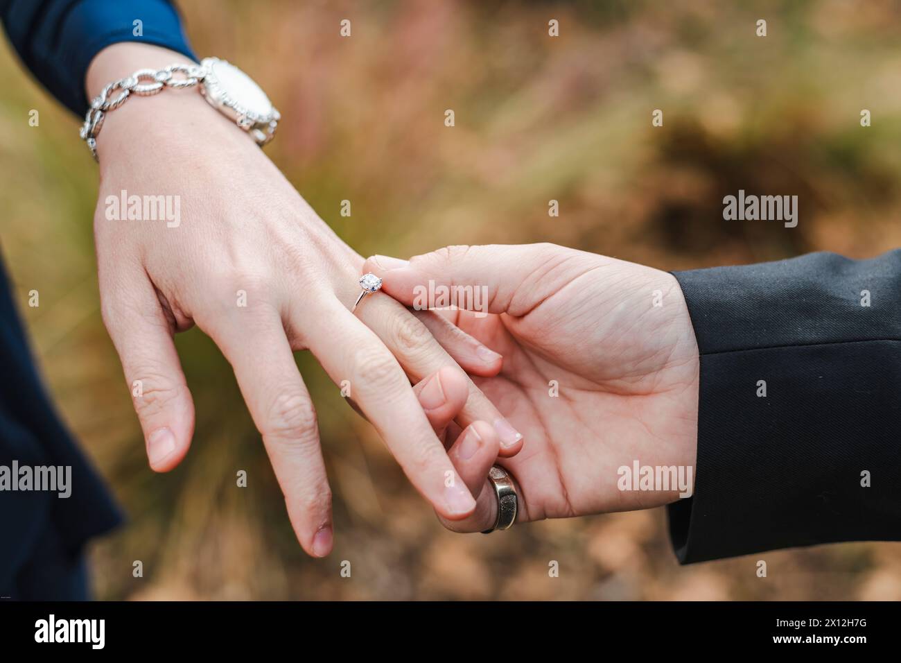 Hände verbunden, ein Verlobungsring mit Diamanten steht für Liebe Stockfoto