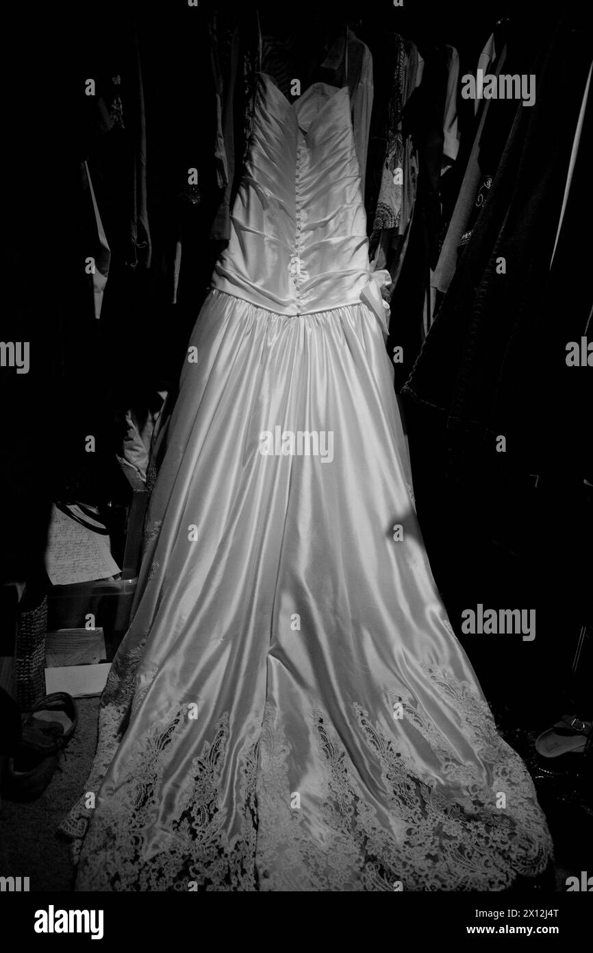 Schwarz-weiß-Foto eines Hochzeitskleides, das aufhängt Stockfoto