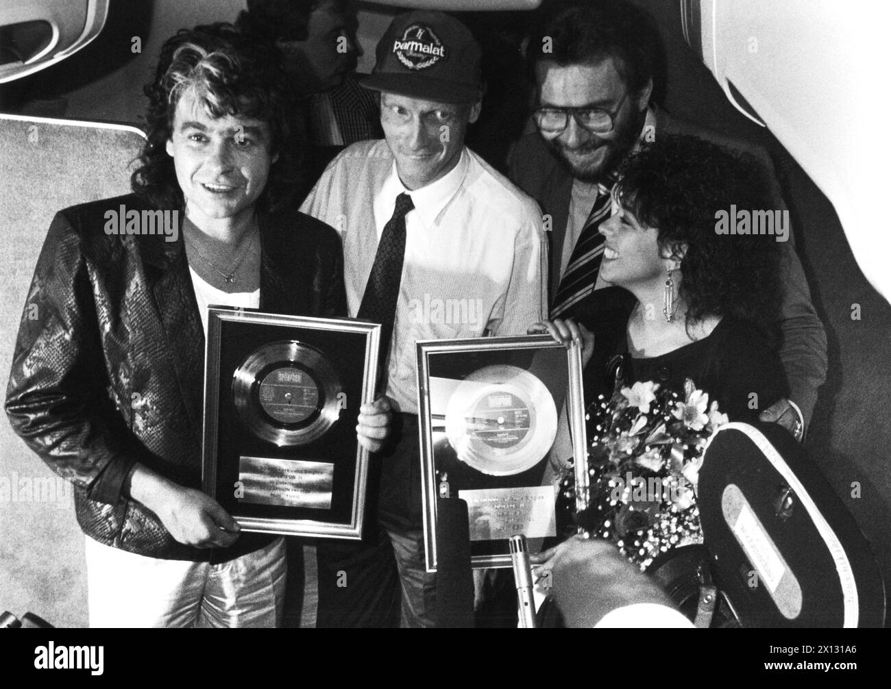 Wien am 11. Juni 1987: Luisa Fernandez (R.) und Peter Kent (l.) erhielten auf ihrem Flug von Wien nach Triest den Goldenen Rekord für ihre Hit-Single Solo por ti in 9000 m Höhe. Das Lied wurde vom Österreicher Chris Duchatschek komponiert. Ebenfalls im Bild: captain Niki Lauda (Mitte) und Gerhard David, CEO des Plattenlabels Bellaphon (2. r.) - 19870611 PD0006 - Rechteinfo: Rights Managed (RM) Stockfoto