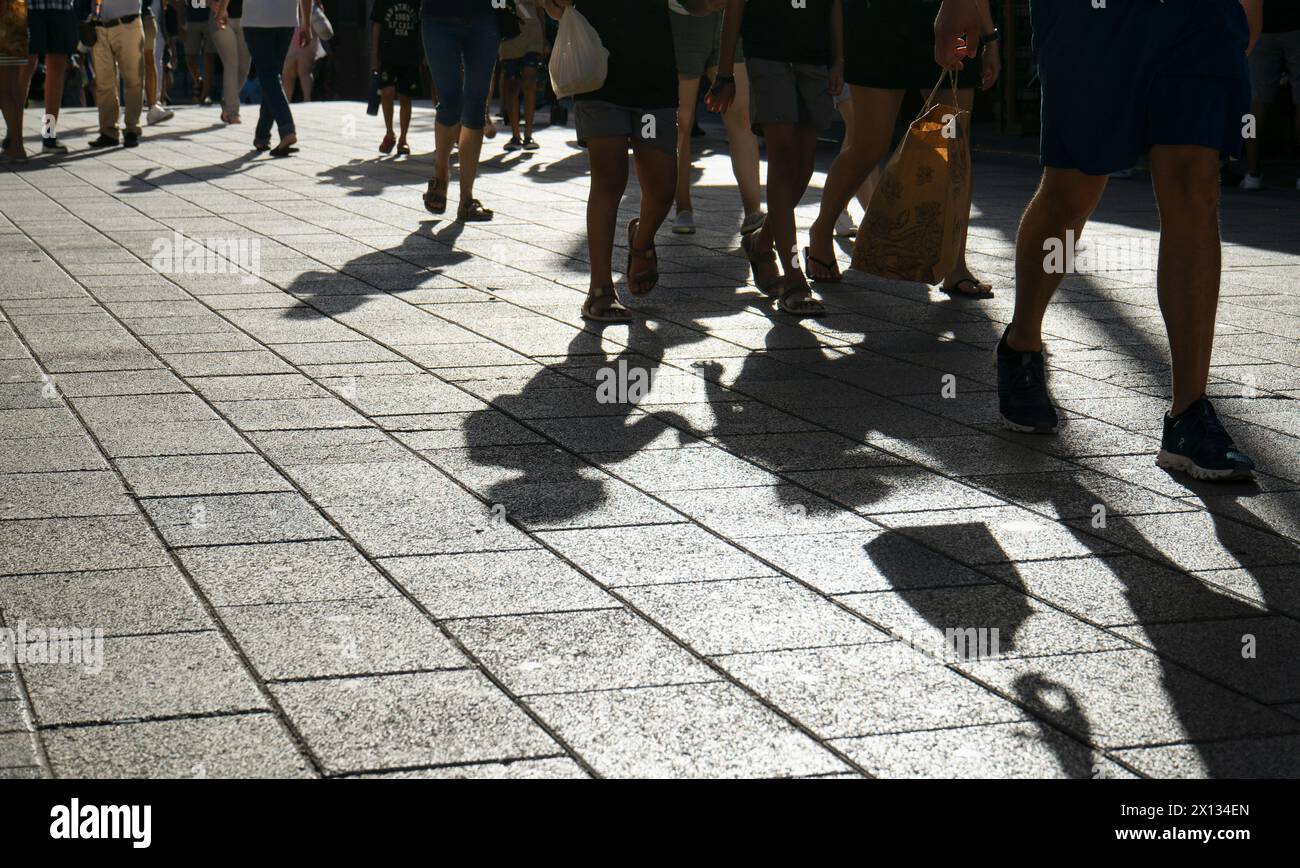 Urbane Schatten von Menschen, die auf einer sonnigen Straße in Playa del Carmen, Mexiko, spazieren gehen Stockfoto