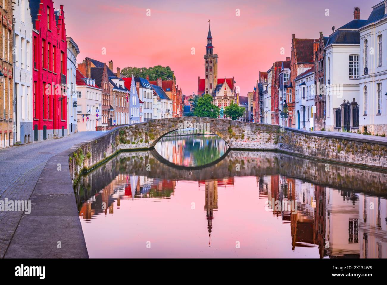 Brügge, Flandern, Belgien. Farbenfrohe Stadtlandschaft bei Sonnenaufgang mit Wasserreflexionen am Spiegelrei-Kanal. Stockfoto