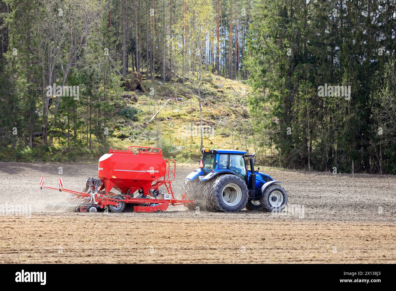 Arbeiten im Feld mit dem blauen Valtra-Traktor und der Horsch Pronto 4DC-Sämaschine an einem Frühlingstag. Salo, Finnland. Mai 2022. Stockfoto