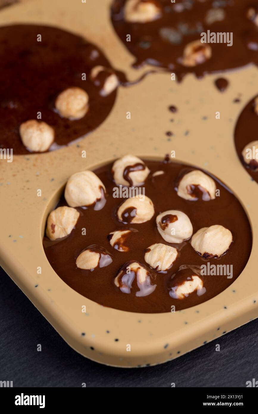 Geschmolzene Milchschokolade mit Nüssen, kochende Schokoladentafeln mit heißer Milchschokolade und Nüssen Stockfoto