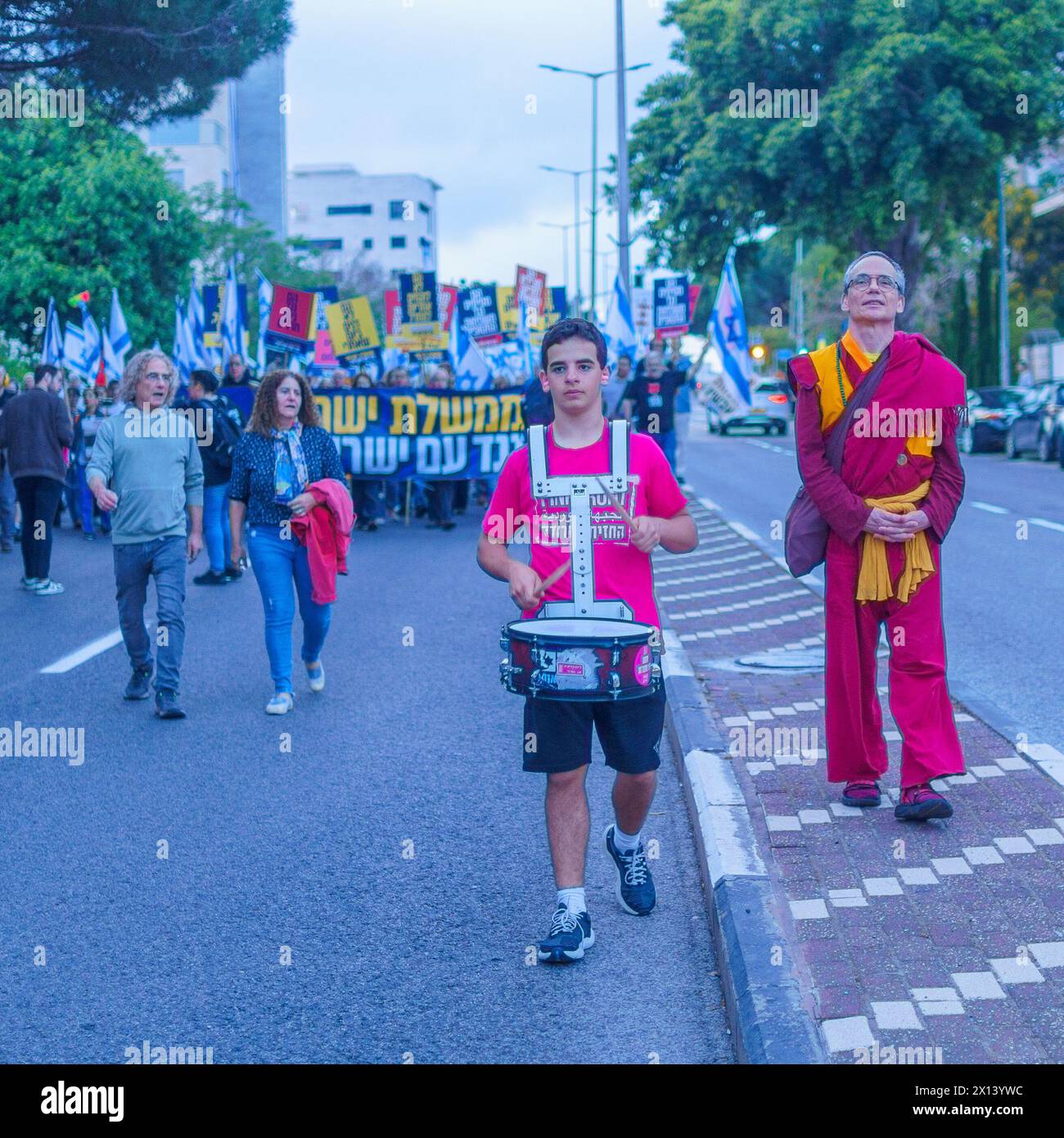 Haifa, Israel - 13. April 2024: Menschen nehmen an einem protestmarsch mit verschiedenen Zeichen und Flaggen gegen die Regierung Teil und rufen zu Neuwahlen auf. Stockfoto