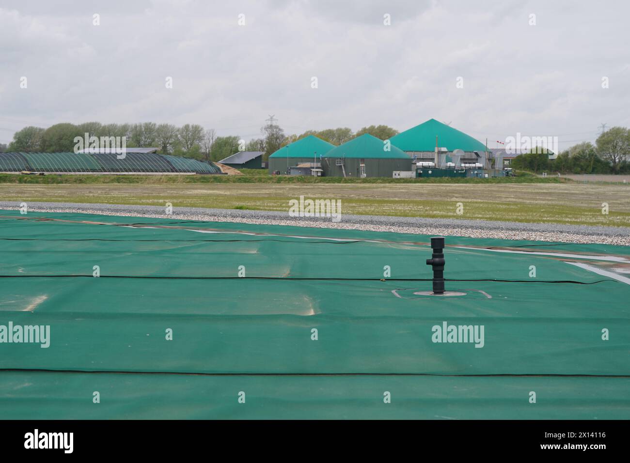 Meldorf, Deutschland. April 2024. Blick vom ersten unterirdischen Speicher Deutschlands auf eine Biogasanlage. Nach dem Beispiel Dänemarks sollen öffentliche Gebäude und Haushalte in Meldorf künftig beheizt und mit Fernwärme und gespeicherter industrieller Abwärme sowie Solarenergie versorgt werden. Quelle: Marcus Brandt/dpa/Alamy Live News Stockfoto