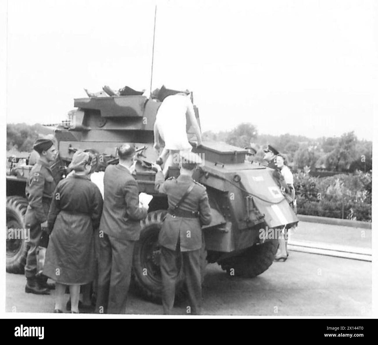 Eine Arbeiterin besteigt ein gepanzertes Auto zur Inspektion und eine kurze Fahrt als Teil der Fahrzeugkontrolle. Stockfoto