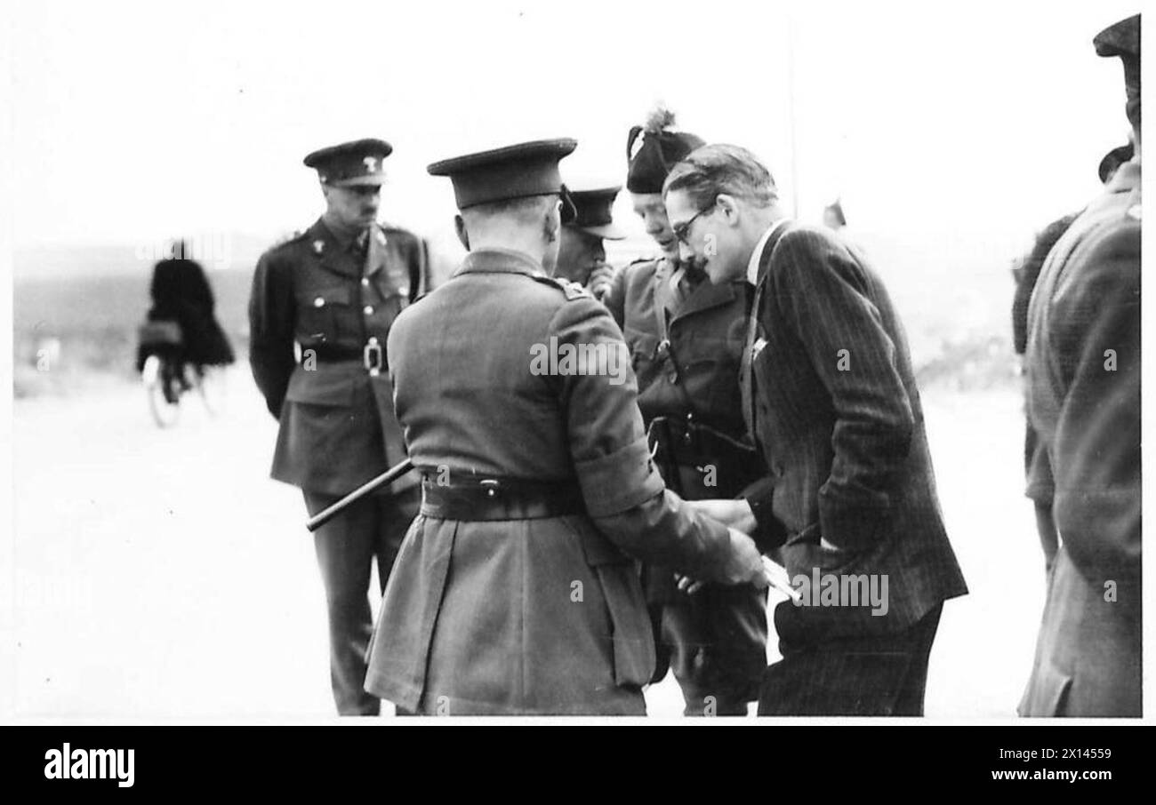 Mr. A. Eden untersucht während eines offiziellen Besuchs eine Karte mit befestigten Küstenschutzmauern. Stockfoto