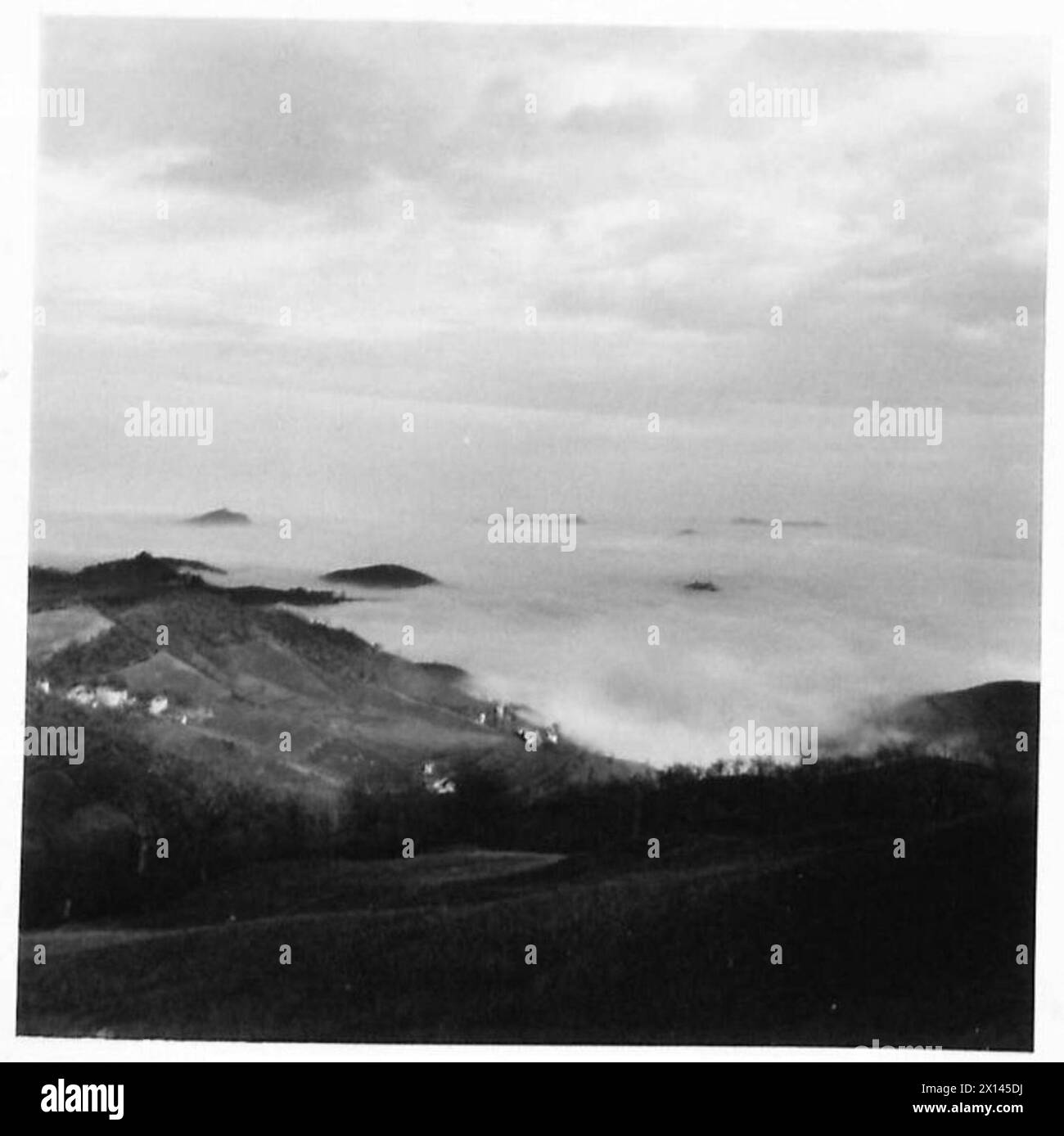 Der Blick von einem Berg zeigt die Landschaft in Richtung Bologna, mit Gipfeln, die teilweise durch niedrige Wolken sichtbar sind, beobachtet von der britischen Armee. Stockfoto