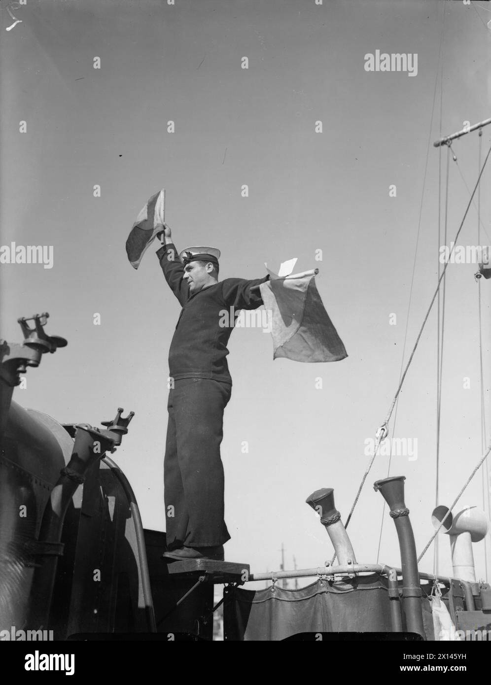 Während des Zweiten Weltkriegs schickt ein griechischer Signaler eine semaphorische Botschaft an Bord der HHMS Admiral Coundouriotis in Alexandria. Stockfoto Während des Zweiten Weltkriegs schickt ein griechischer Signaler eine semaphorische Botschaft an Bord der HHMS Admiral Coundouriotis in Alexandria. Stockfoto