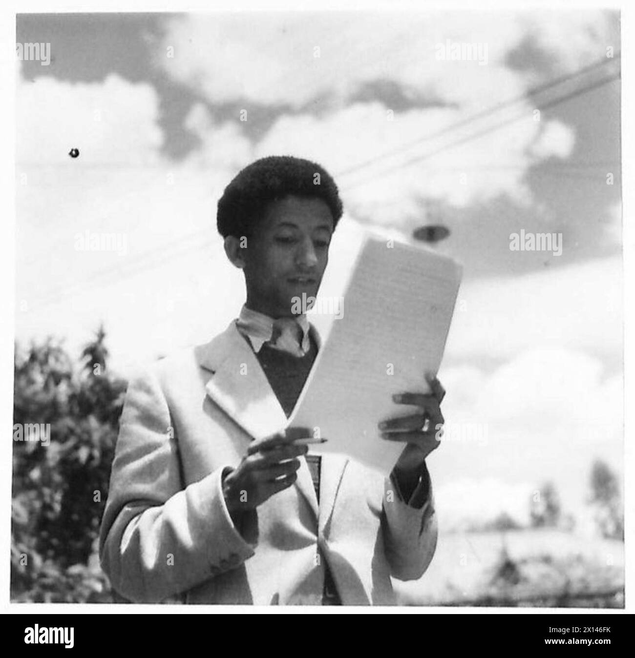 Ein Fernsehsender liest ein Drehbuch vor der Addis Abeba Broadcasting Station. Stockfoto