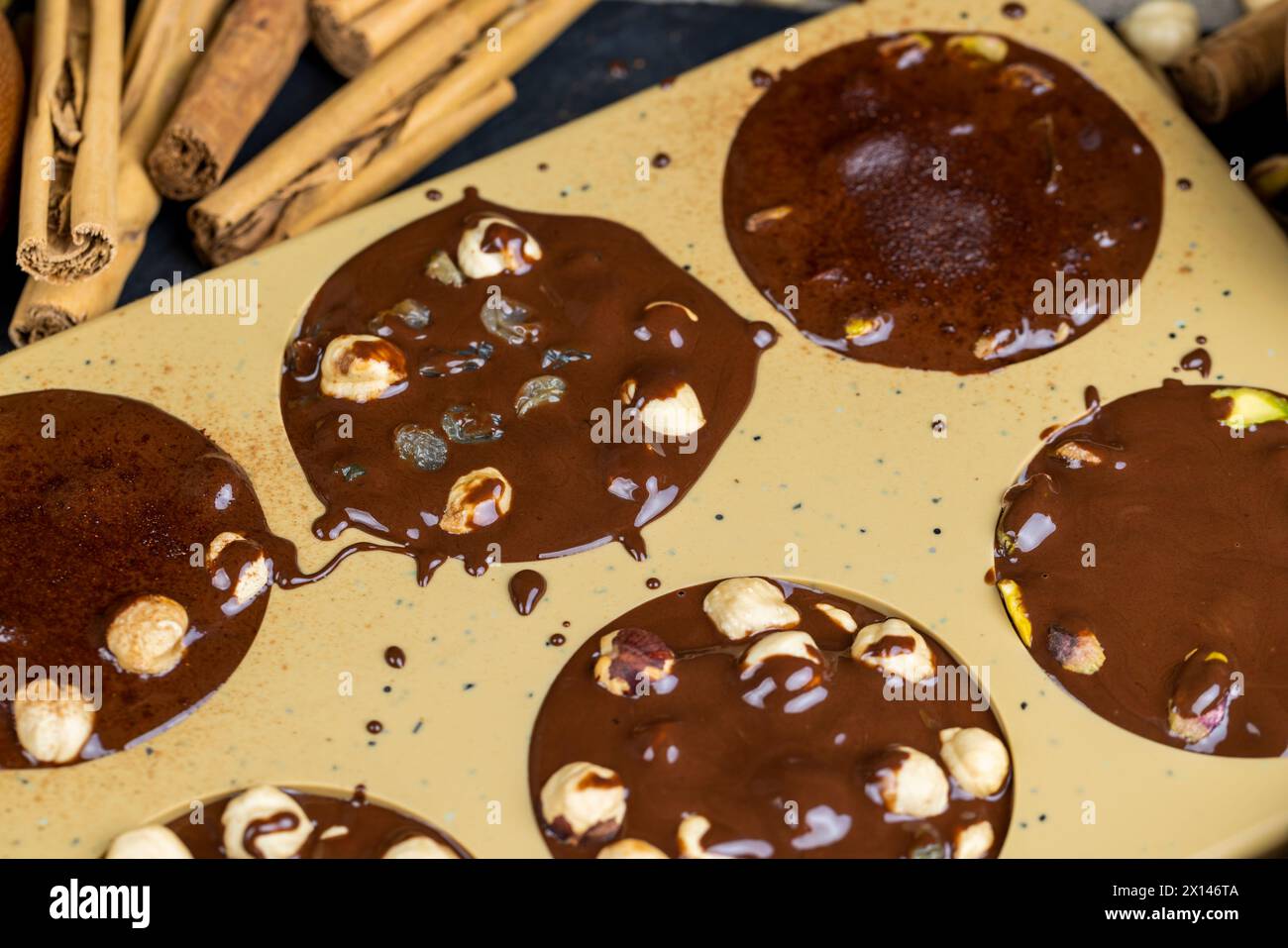 Geschmolzene Milchschokolade mit Nüssen, kochende Schokoladentafeln mit heißer Milchschokolade und Nüssen Stockfoto
