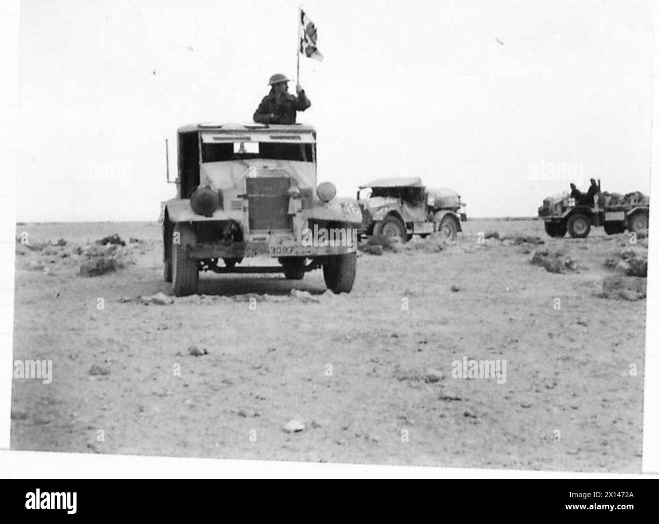 Ein NCO signalisiert den Start eines Wüstenwasserkonvois, der während Operationen der britischen Armee mit einer Flagge nach Süßwasser sucht. Stockfoto